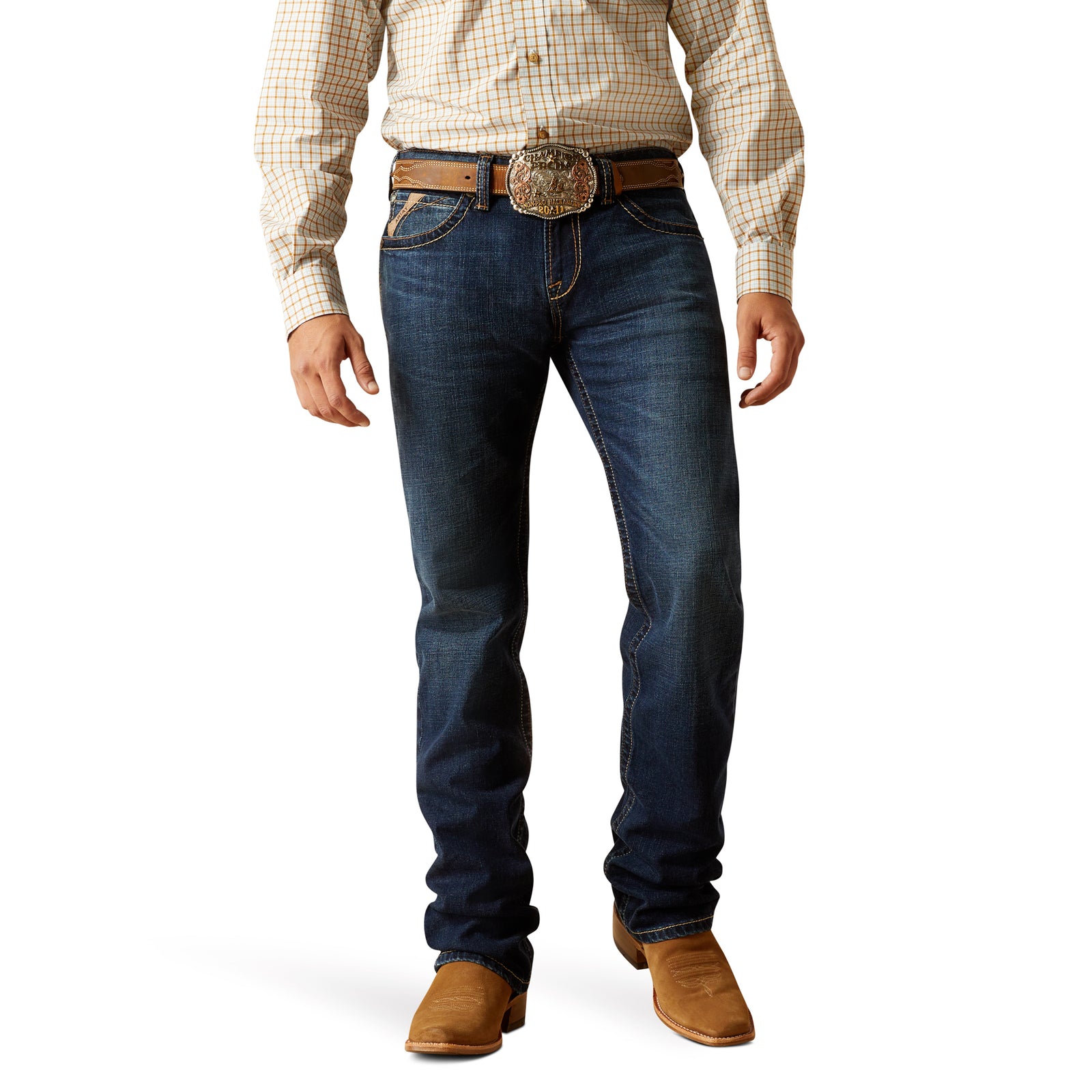 A man wearing Ariat M7 Gleeson Men's Slim Straight Leg Jean with a checkered shirt and a belt, standing against a white background.