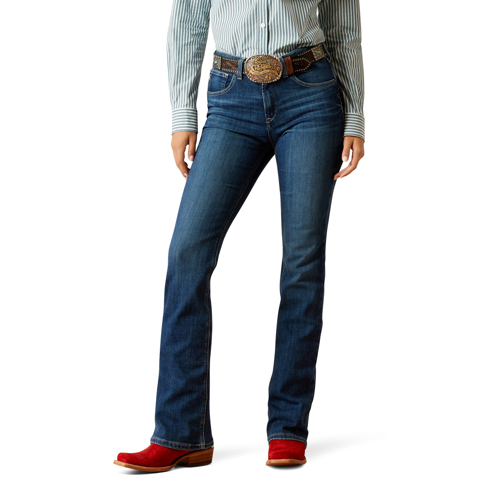 Ariat Women's Lydia High Rise Boot Cut Jean. A woman standing, wearing blue high-waisted boot cut jeans and red boots.