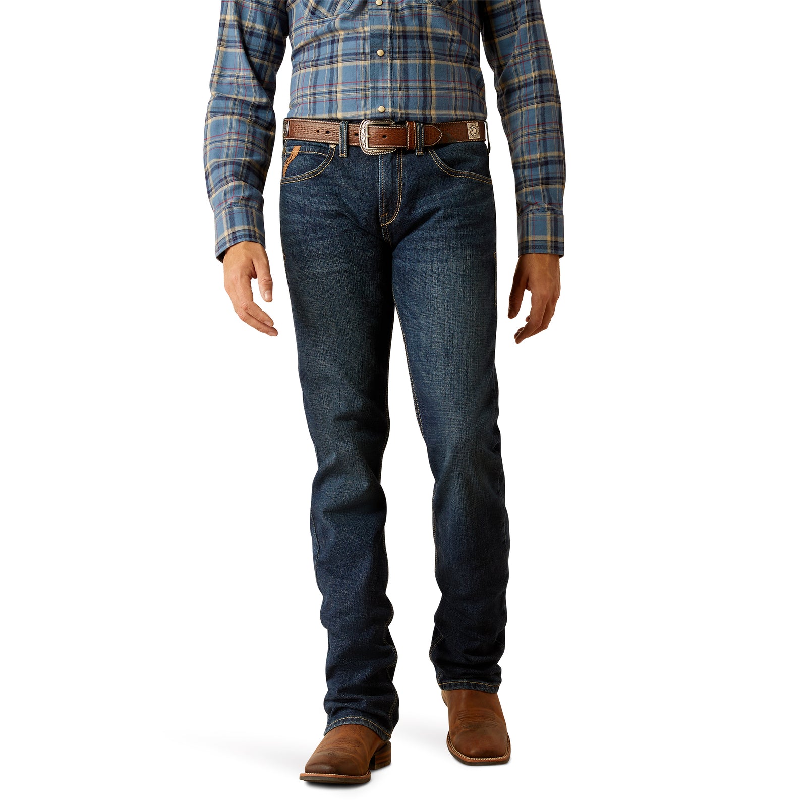 A man standing straight, wearing a blue checkered shirt and the Ariat Men's M7 Tucker Slim Straight Jean with a pair of brown boots.