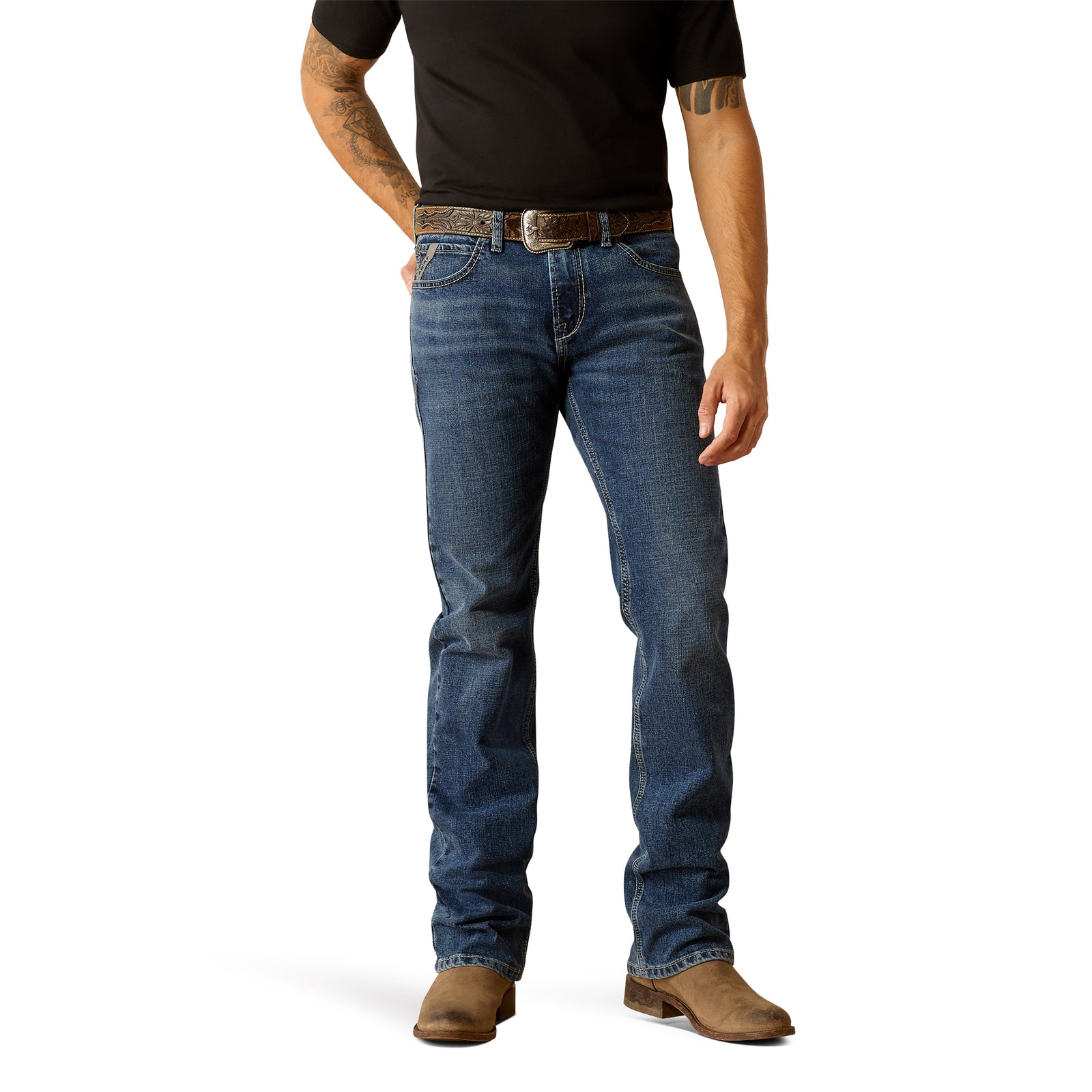 Ariat Men's M7 Scout Slim Straight Jean. A man standing straight, wearing slim-fit blue jeans and brown boots.