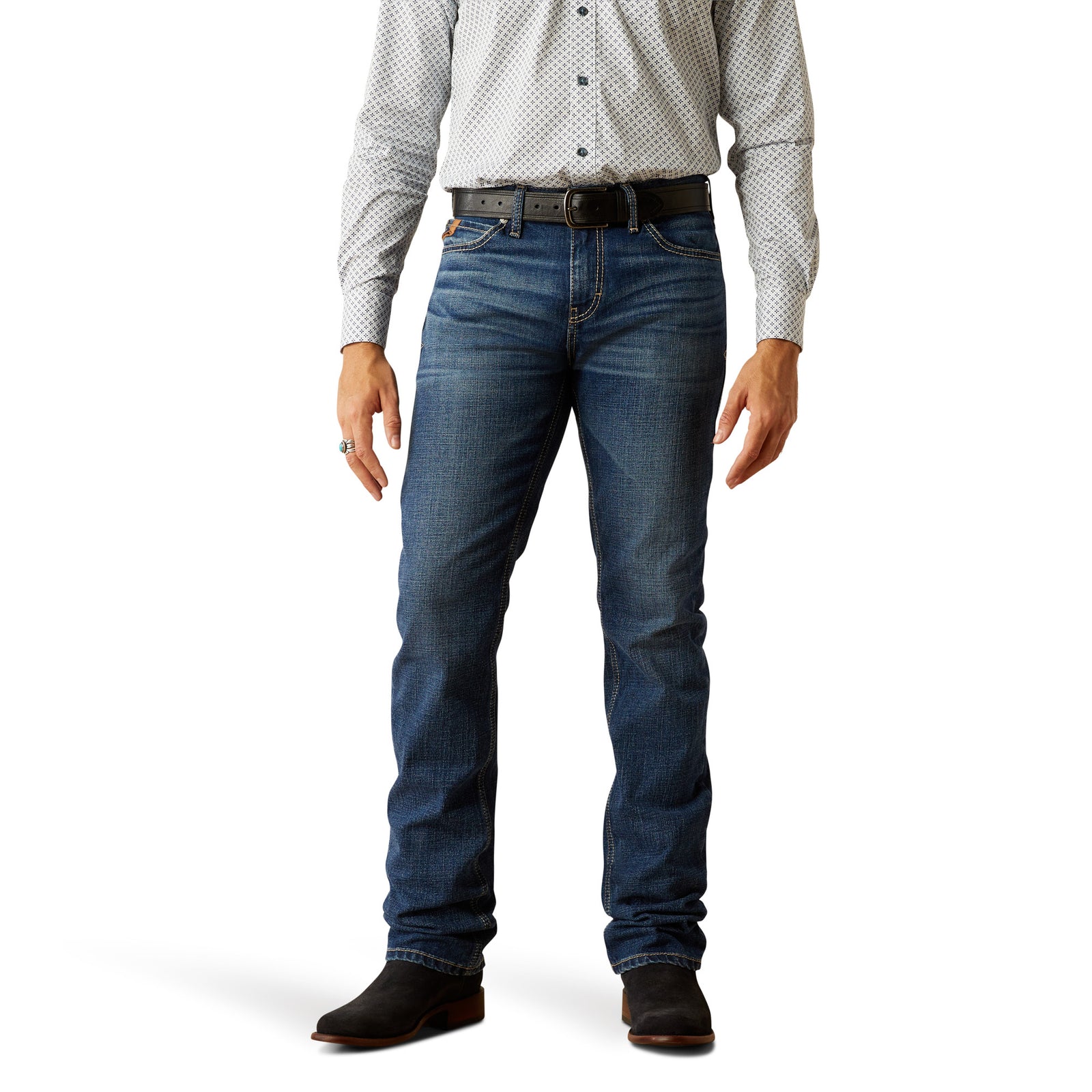 A man standing upright wearing a pair of Ariat Men's M8 Modern Ashton Straight Leg Jeans with a checkered shirt and boots.