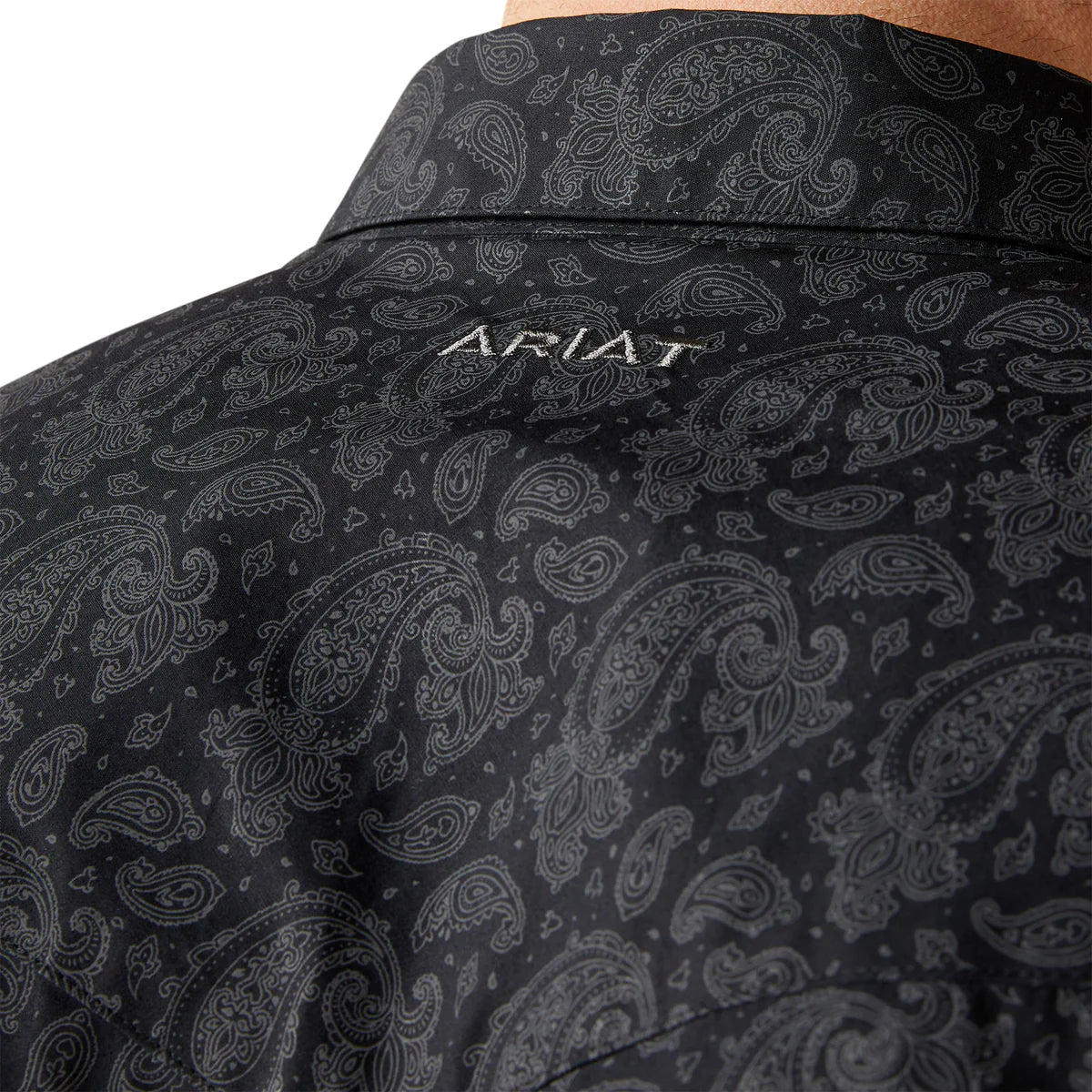 Black paisley patterned shirt with 'Ariat' branding on a white background