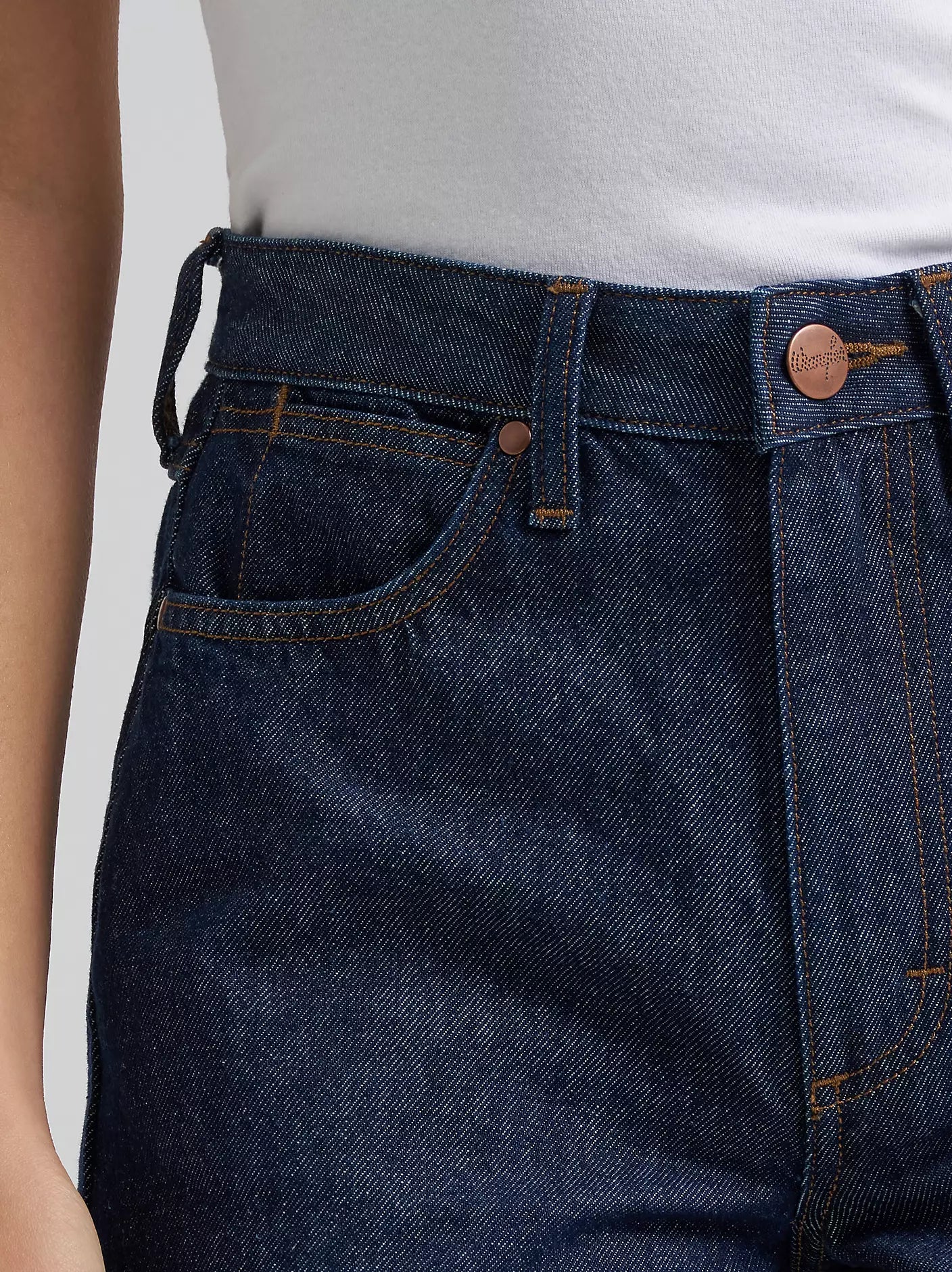 Close-up of dark blue jeans with a white background