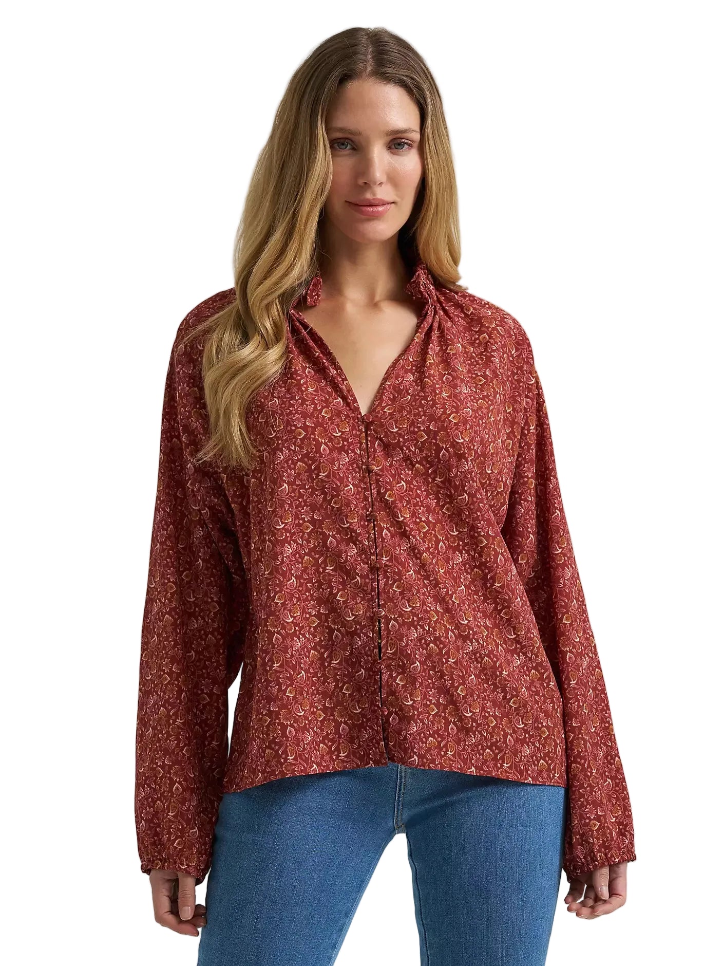 Woman wearing a red floral blouse and blue jeans on a gray background