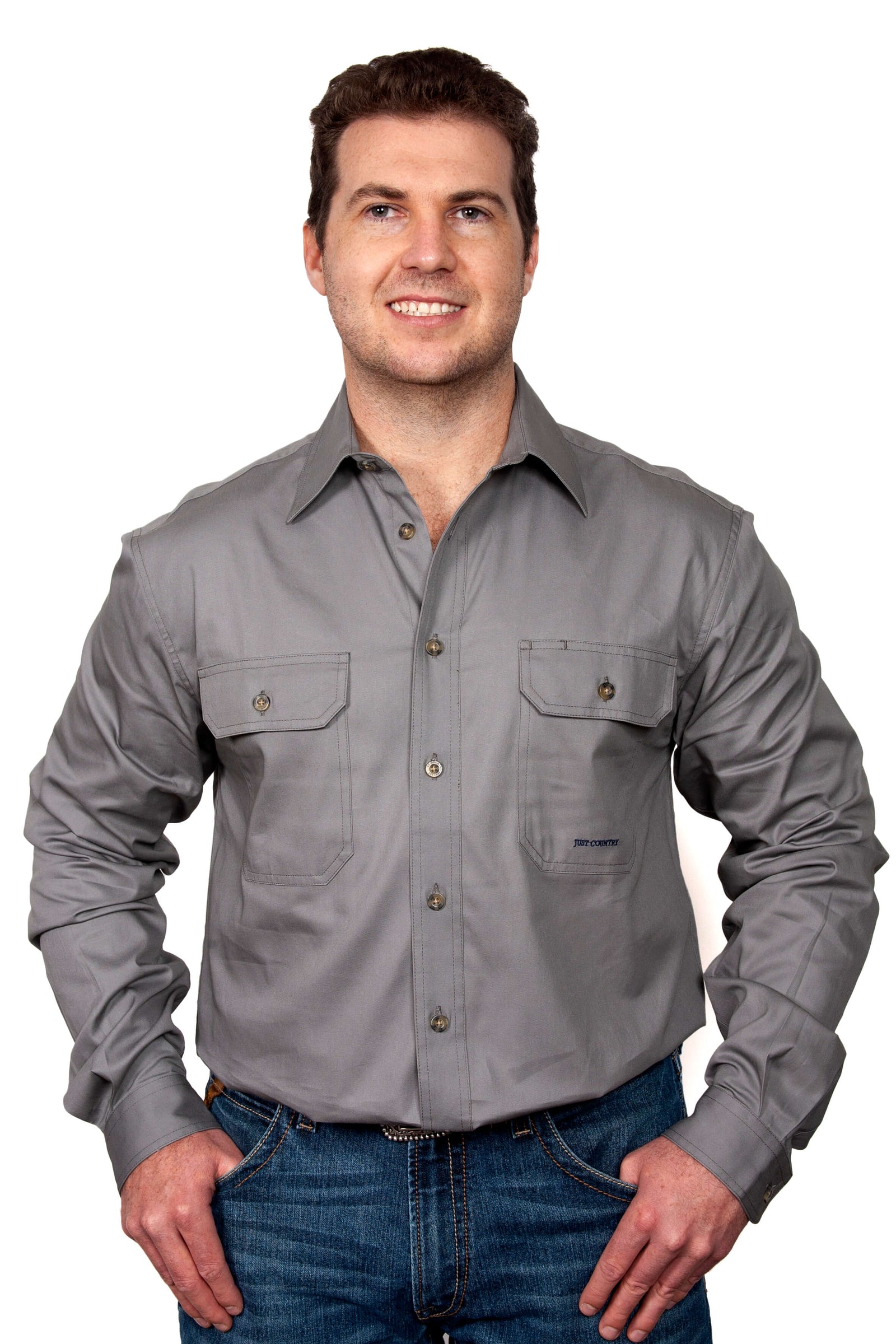 Just Country Men's Evan L/S Workshirt. A man wearing a long-sleeved gray workshirt with full buttons, collar, and two chest pockets.