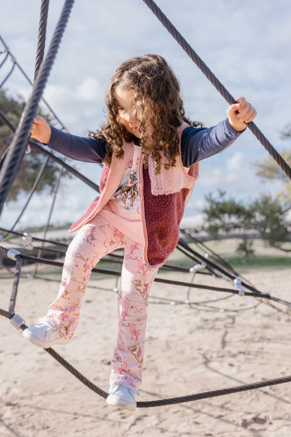 Child playing on a rope structure at a playground