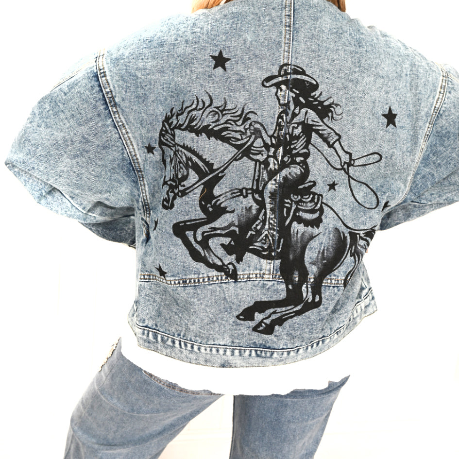 Victory Stallion Denim Jacket. Denim jacket with a graphic of a cowgirl riding a horse on the back.