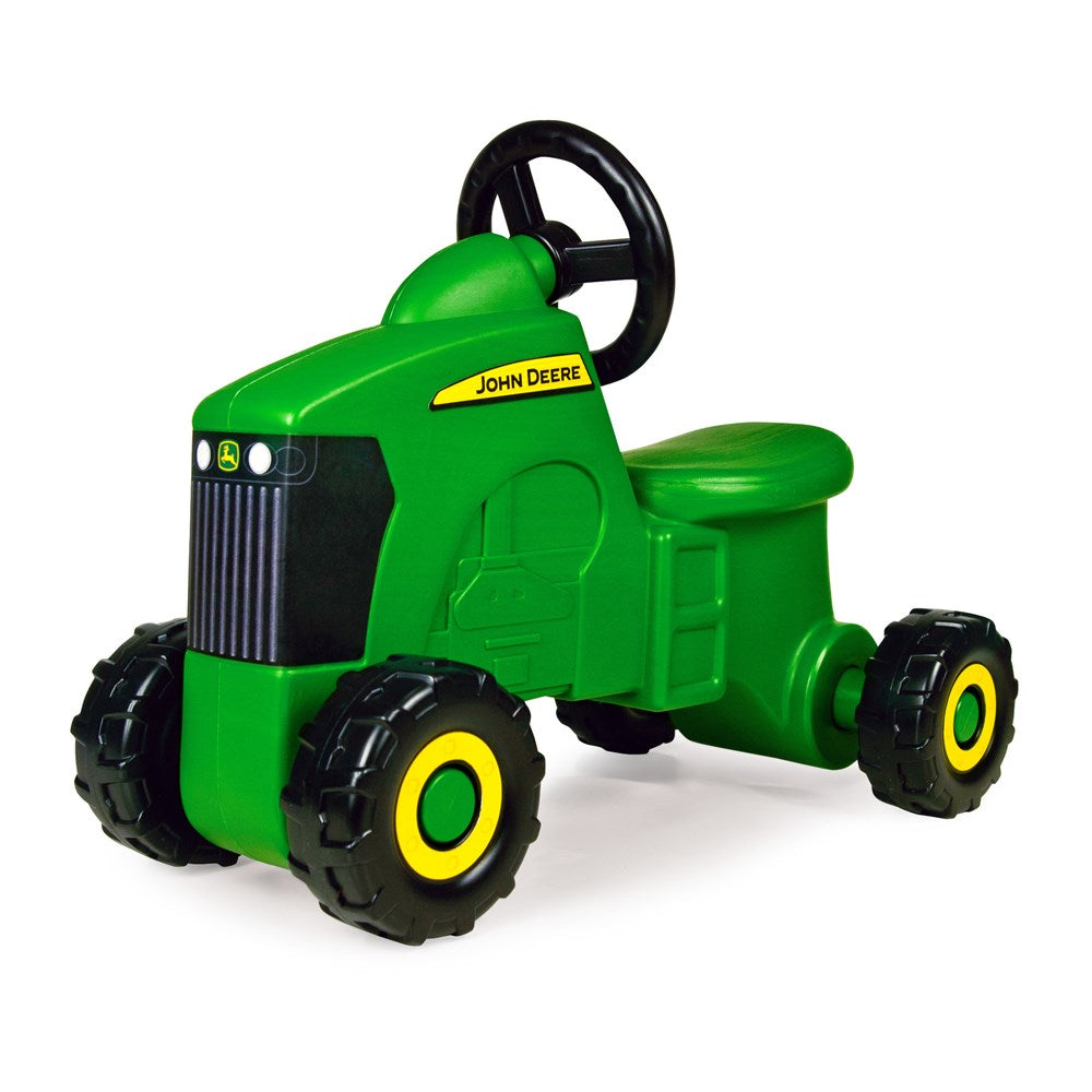 John Deere Foot to Floor - Tractor Ride-On. Green toy tractor with black wheels and yellow accents on a white background