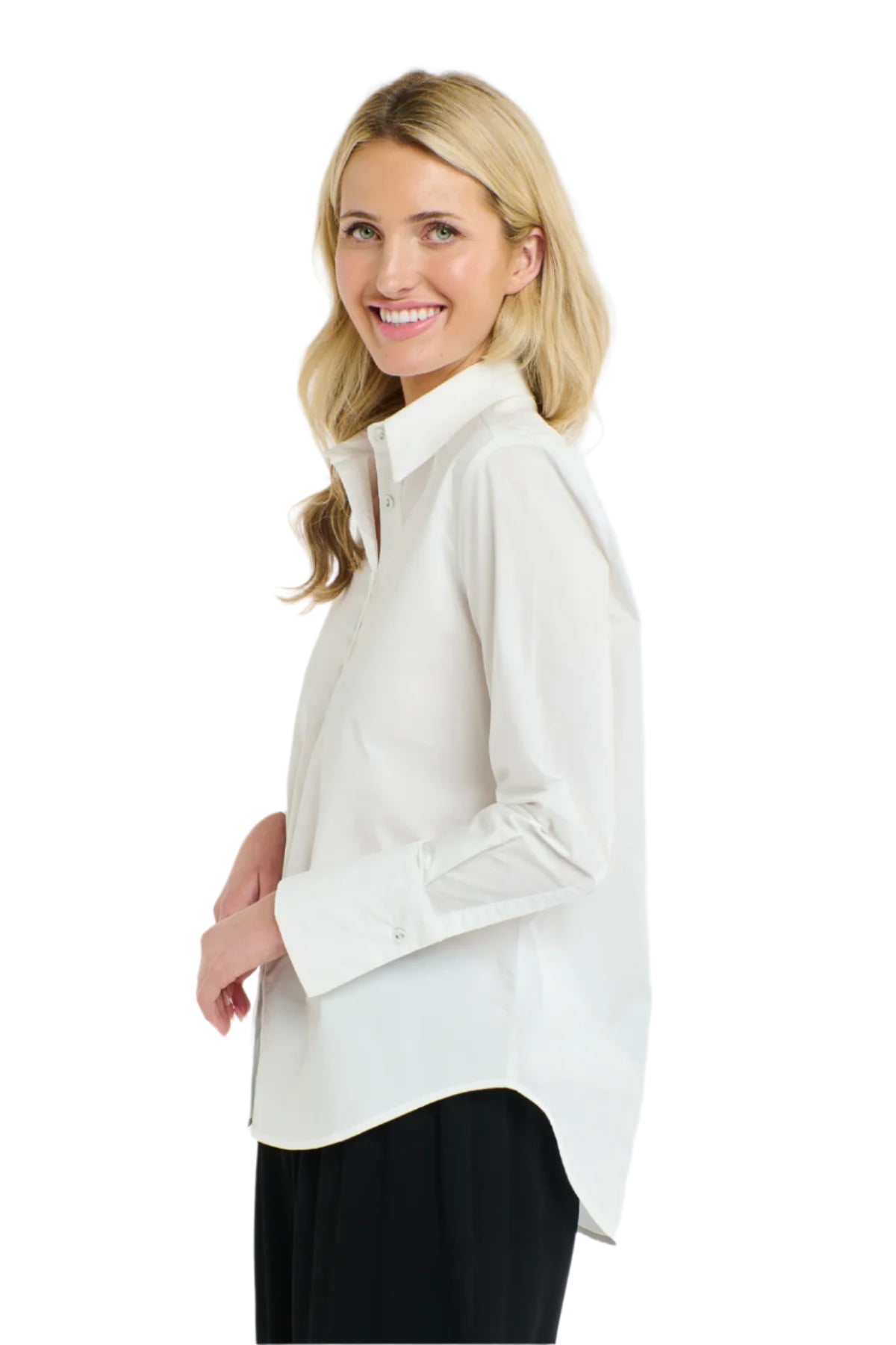 Side view of a woman wearing a 365 Women's Classic L/S Shirt. White button-up shirt on a white background