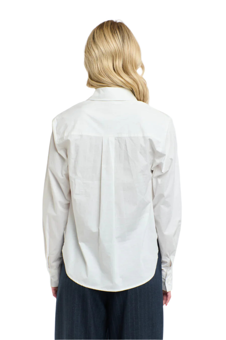 Rear view of a woman wearing a 365 Women's Tuxedo Shirt. A white blouse with ruffled details on a white background