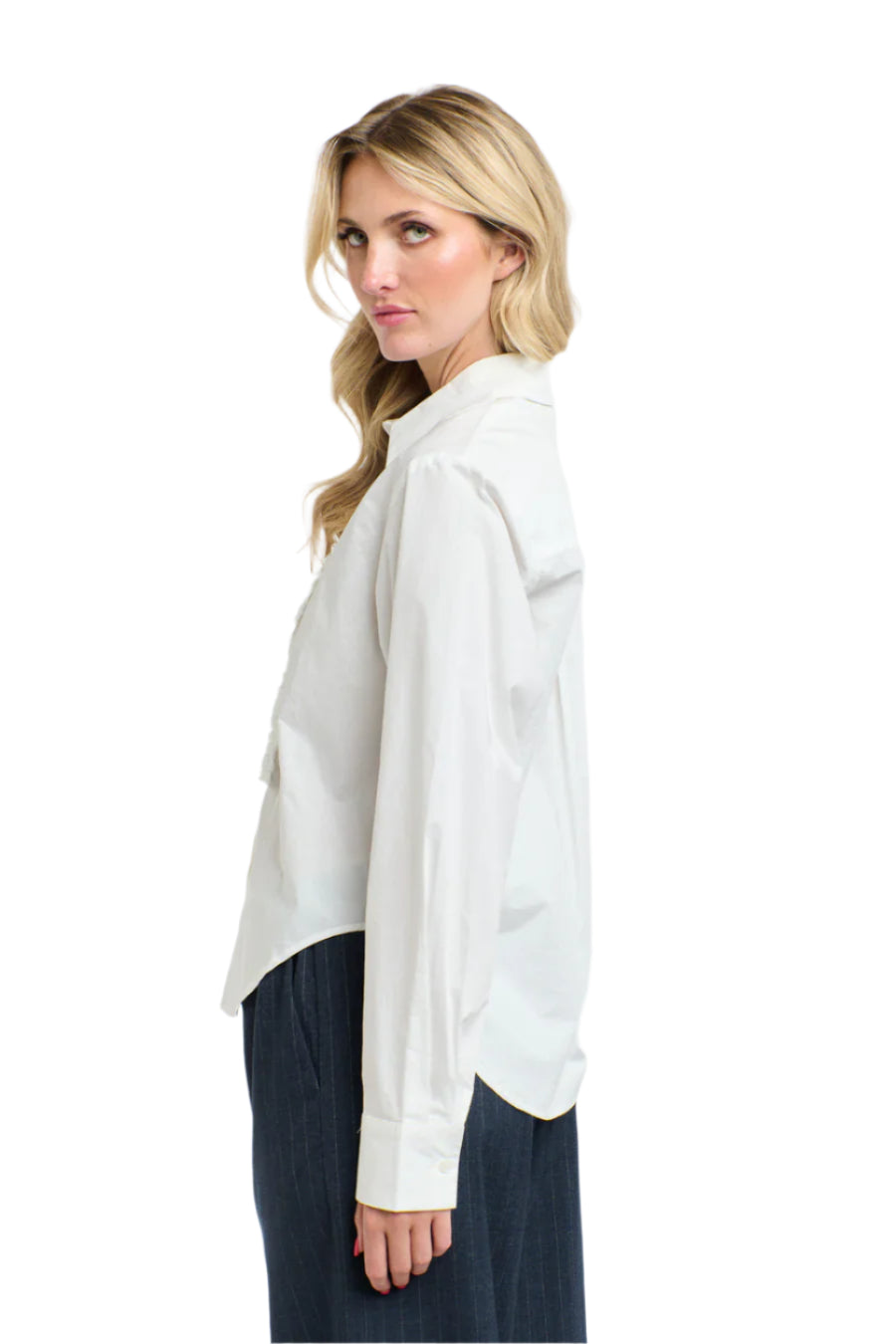 Side view of a woman wearing a 365 Women's Tuxedo Shirt. A white blouse with ruffled details on a white background