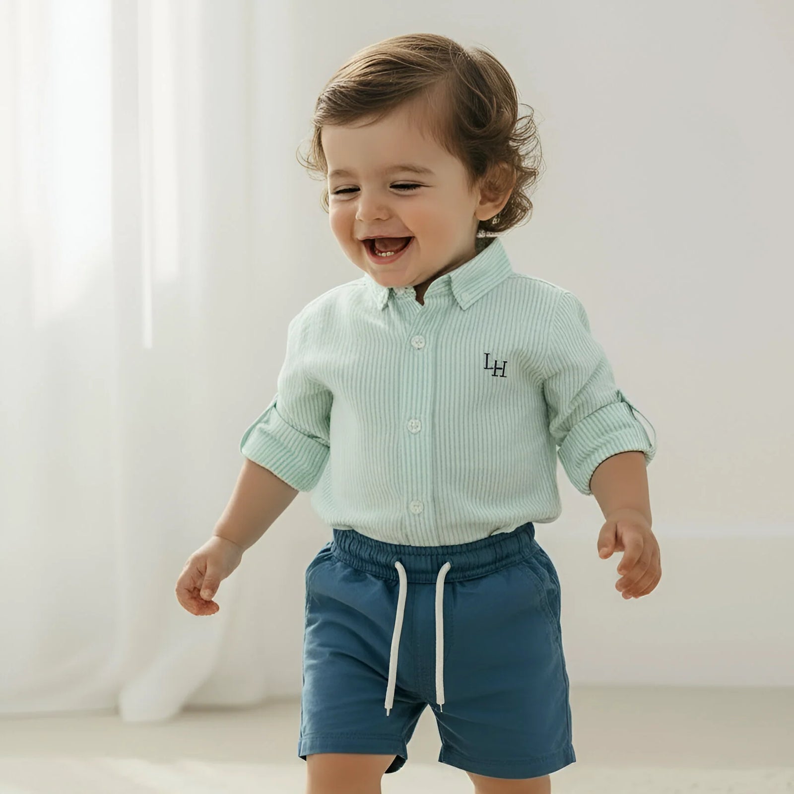 Child wearing a light green checkered shirt and blue shorts on a white background