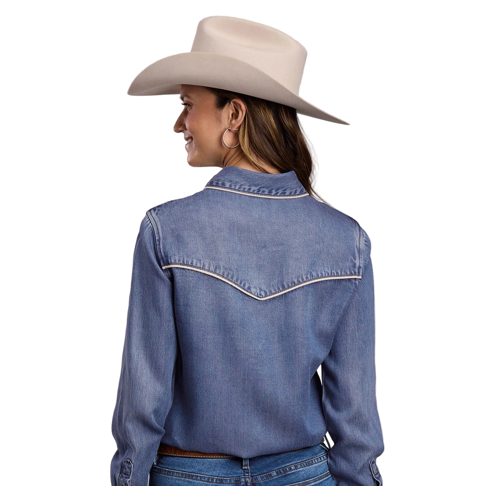 Woman wearing a blue denim jacket and beige cowboy hat on a gray background