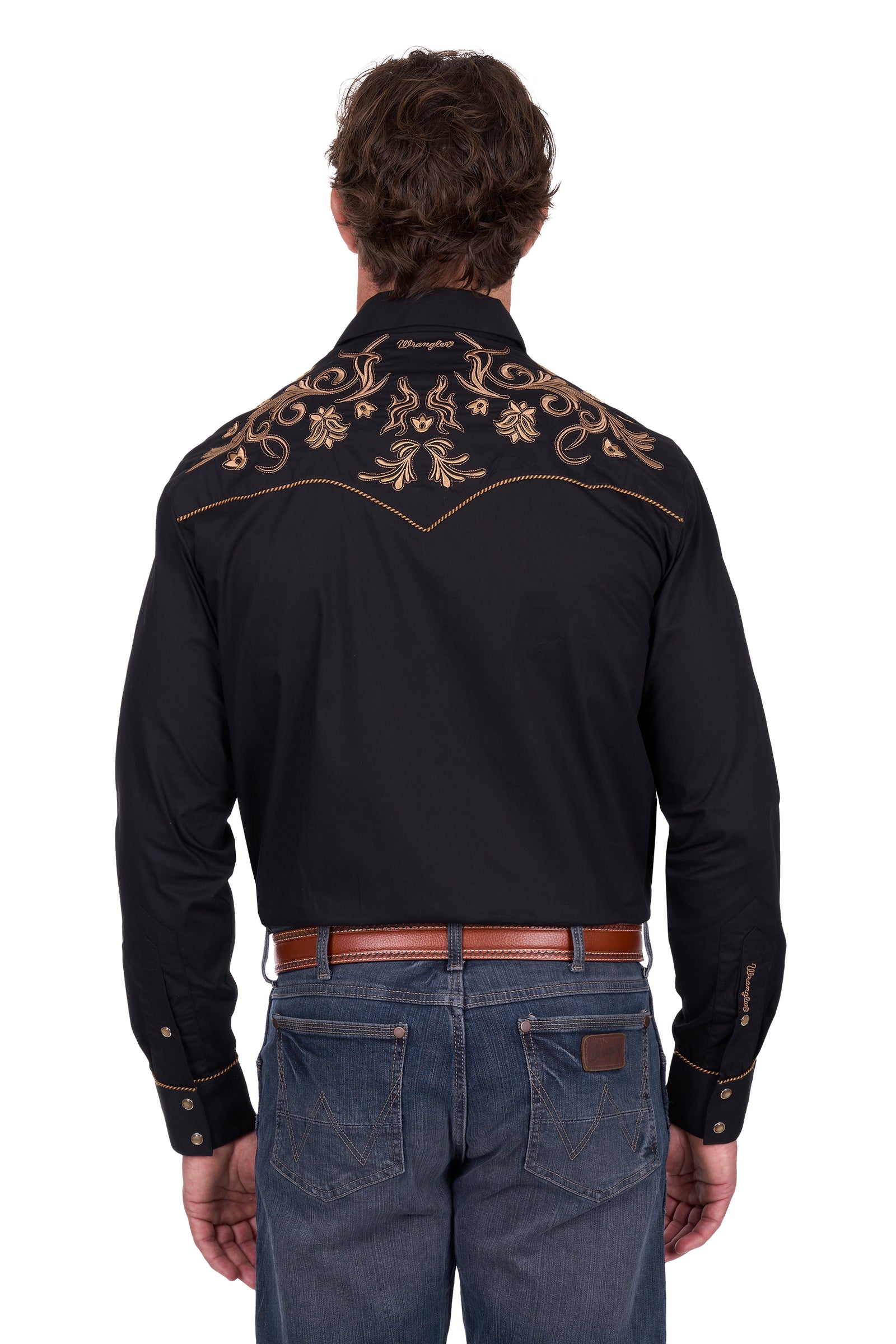 Man wearing a black embroidered shirt and jeans on a white background