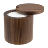 A cylindrical wooden salt container with a dark brown wood grain finish, shown with its lid propped open to reveal white coarse salt inside. The container has a small brass hinge accent on the lid.