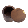 A dark brown wooden cylindrical container with its round lid leaning against it, featuring a small brass keyhole cutout on the lid, set against a plain white background.
