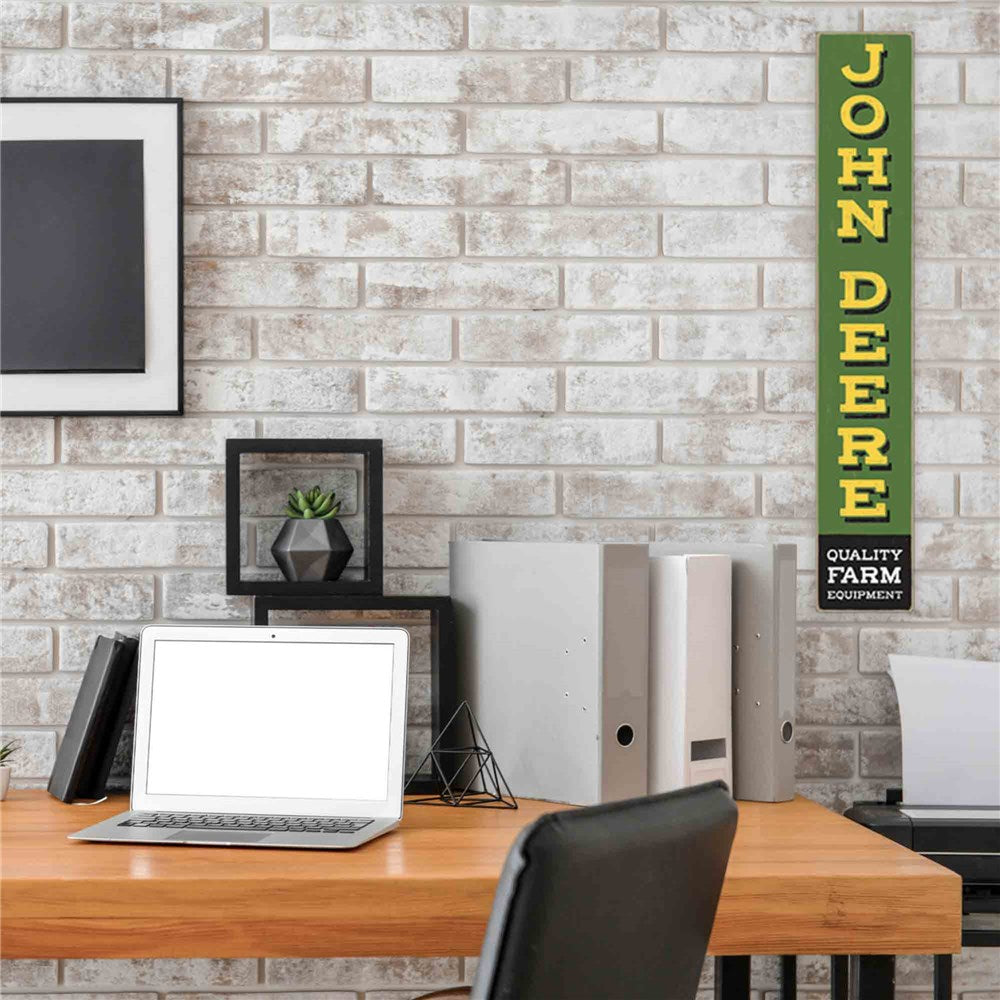 John Deere Quality Farm Equipment Vertical Rustic MDF Wall Décor. Home office with a desk, laptop, and John Deere sign on a brick wall.