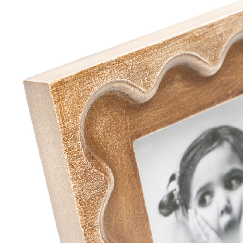 Designer Photo Frame. Close-up of a wooden photo frame with a scalloped edge, featuring a black and white photo of a child.