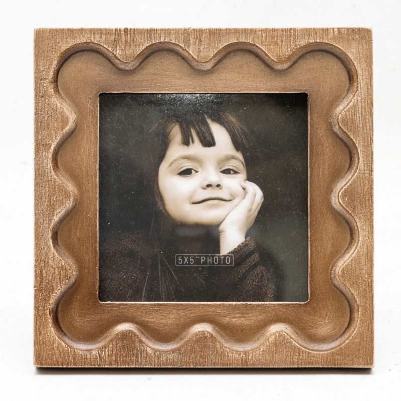 Designer Photo Frame. Wooden photo frame with a wavy edge containing a black and white photo of a child.
