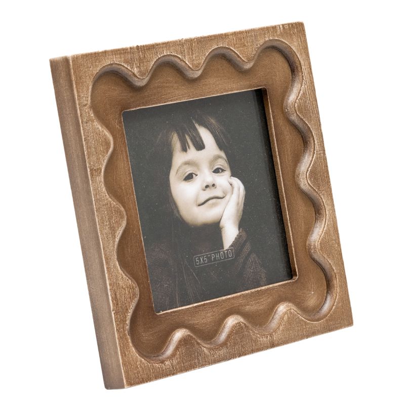 Designer Photo Frame. Wooden photo frame with wavy design holding a photo of a child on a white background