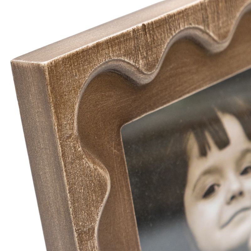 Designer Photo Frame. Close-up of a wooden photo frame with a child's face inside.