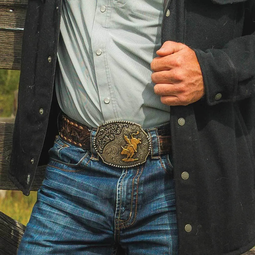 Person wearing a black jacket, light shirt, blue jeans, and a decorative belt buckle.