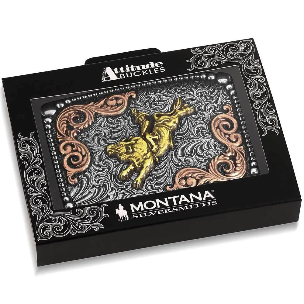Montana Silversmiths buckled hardware in a black presentation box, featuring a silver-toned engraved background with a raised gold buckled rider motif and rose-gold scrollwork.