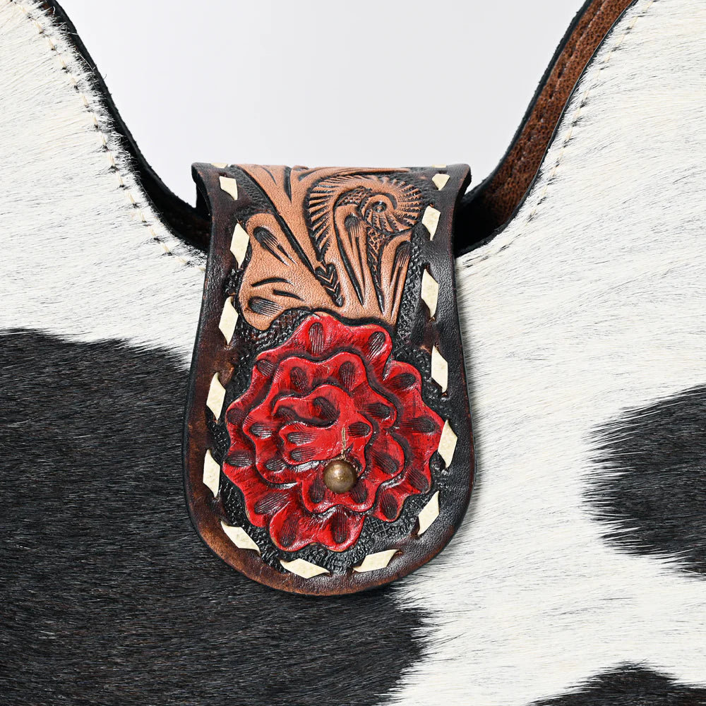 Close up of American Darling Cow hide western handbag with decorative tooled roses strap on a white background