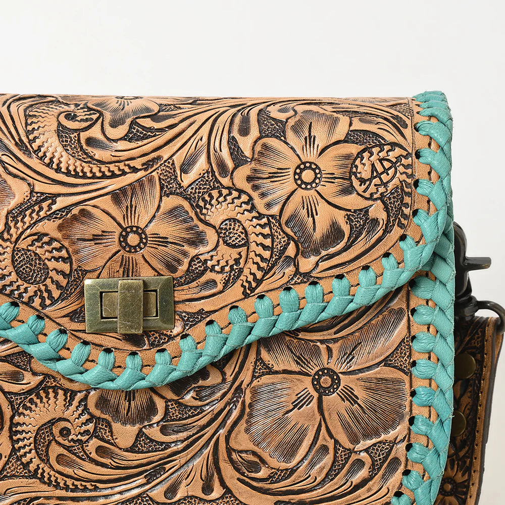 American Darling ooled Leather Crossbody Bag with Whipstitch Trim. Leather handbag with intricate floral patterns and turquoise accents on a light background