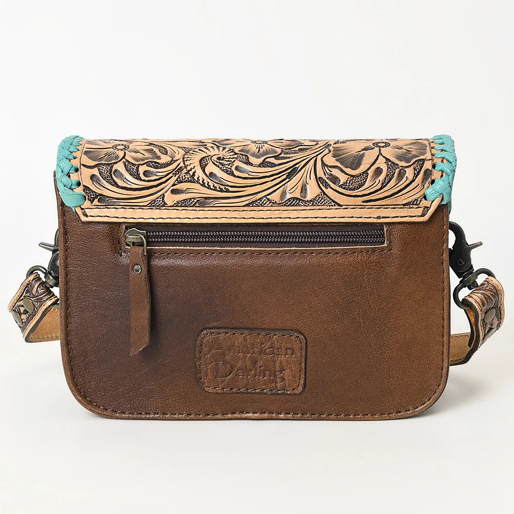 American Darling ooled Leather Crossbody Bag with Whipstitch Trim. Brown leather crossbody bag with intricate tooled design and turquoise accents on a white background
