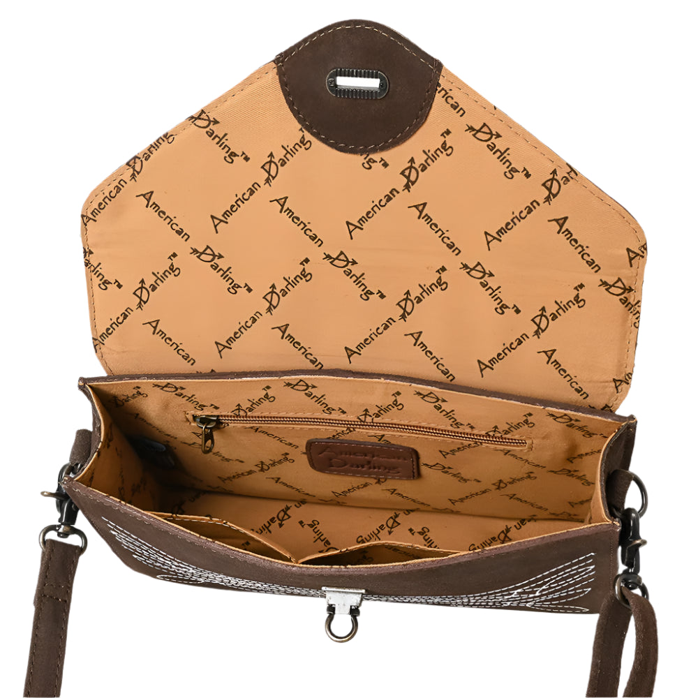 Inside of an American Darling suede brown women's envelope handbag with floral embossing and a shoulder strap.