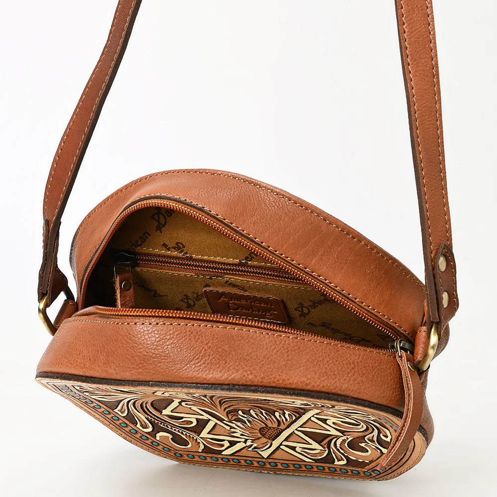 American Darling brown, circular, tooled leather western handbag with floral patterns and a shoulder strap.