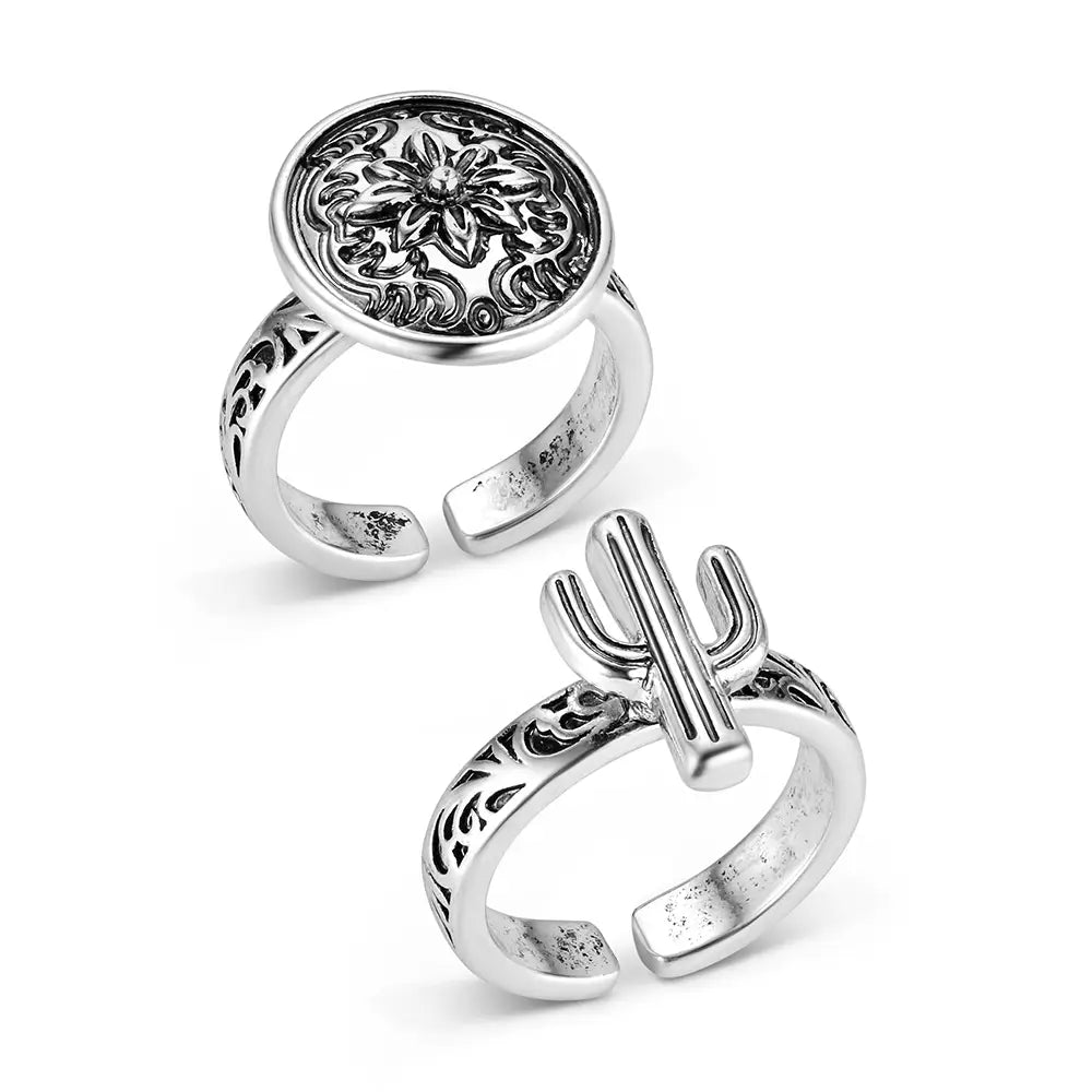 Two silver rings with intricate designs on a white background