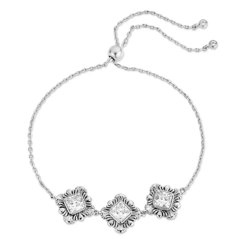 Silver bracelet with three diamond-like stone accents on a white background