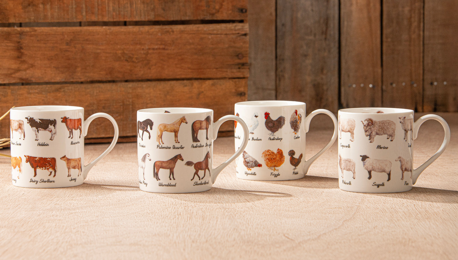 Four mugs with animal illustrations on a wooden surface and background