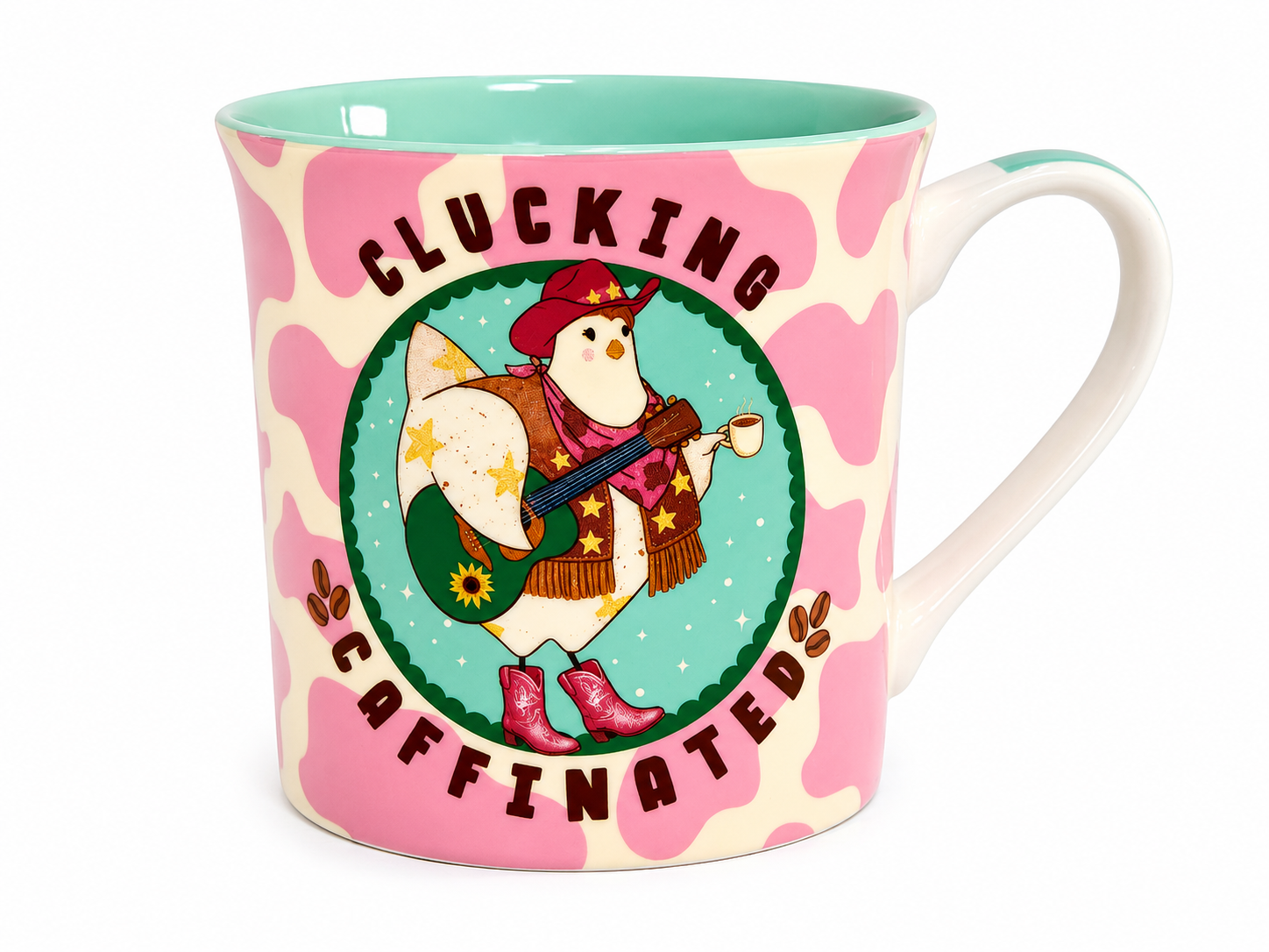 A ceramic coffee mug with a pink and cream cow print pattern, featuring a central illustration of a penguin wearing a cowboy hat and boots, with the text 'CLUCKING CAFFINATED' on a white background.