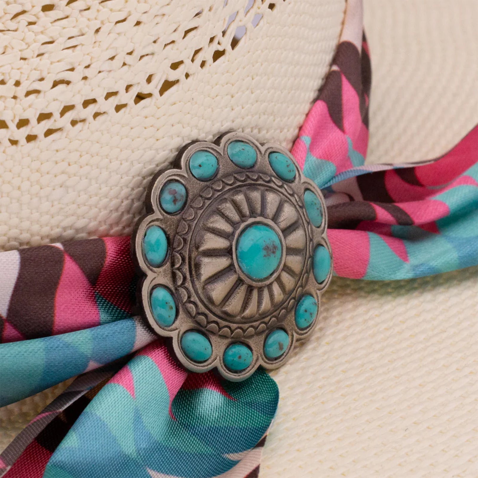 Charlie 1 Horse Hissy Fit Straw Cowboy Hat. A woman's beige straw cowboy hat with a multicolored fabric hatband featuring a floral pattern and a silver concho with turquoise detail.
