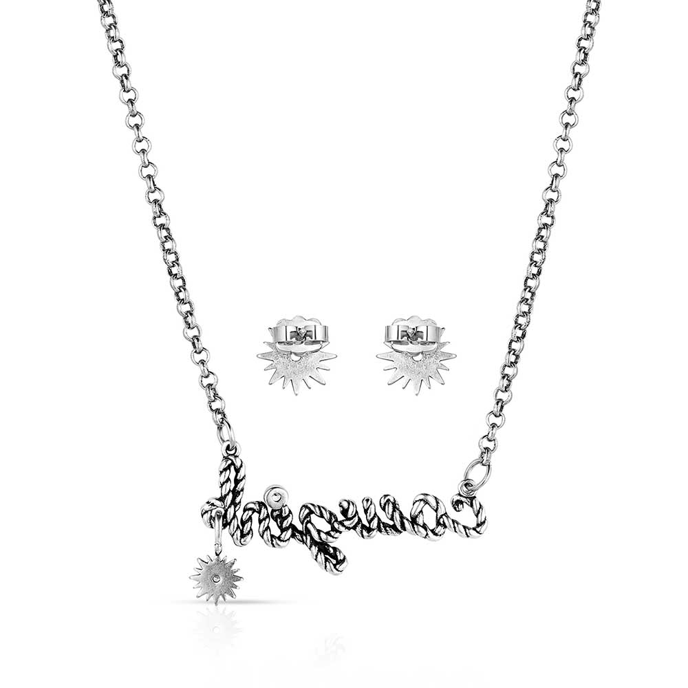 Montana Silversmiths For The Cowgirls Jewellery Set. A jewelry set including a necklace with the text 'Cowgirl' in a cursive writing design and clear cubic zirconia crystals in the center of the earrings, both with silver-tone rope details on a chain, and silver-tone spikes around the crystals.