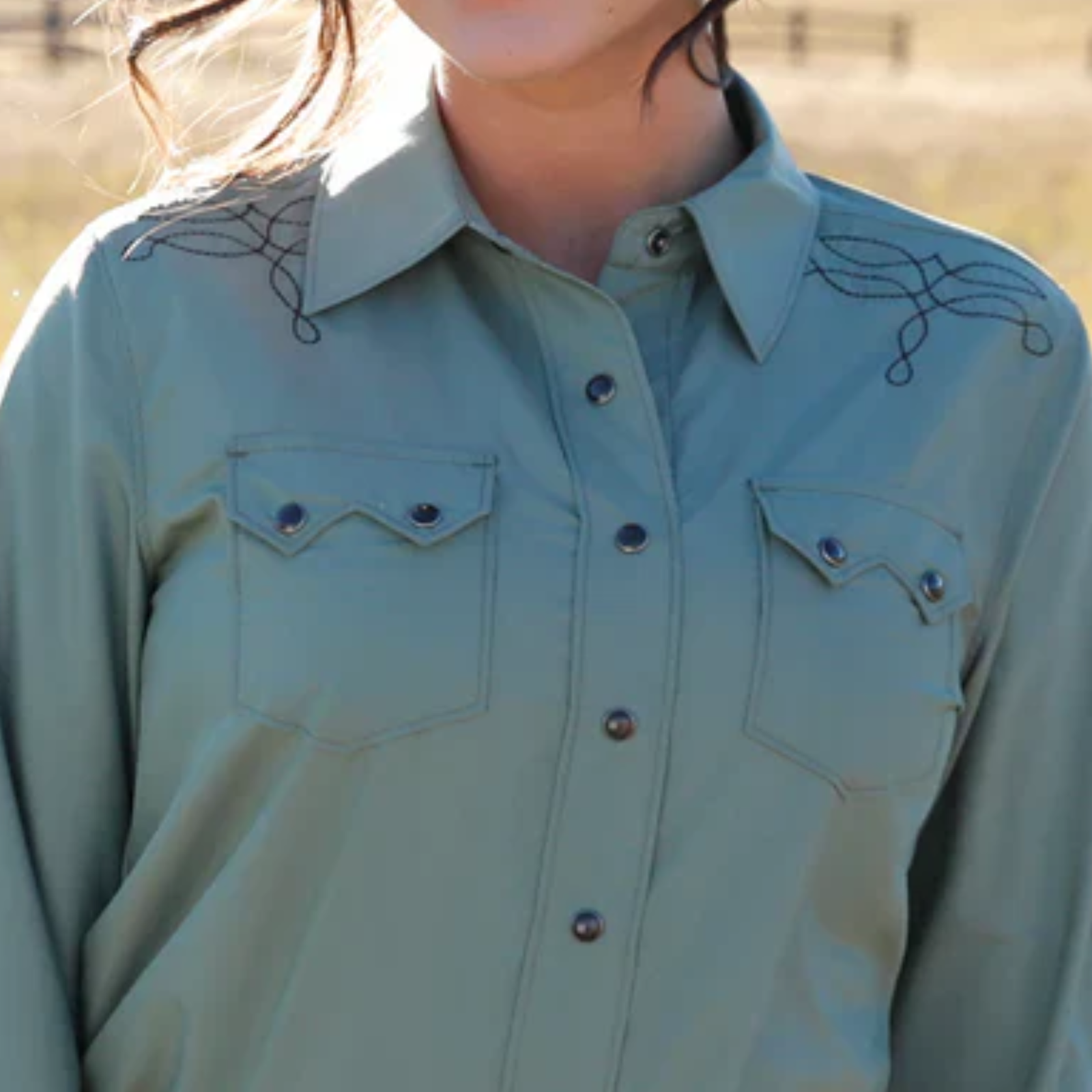Light blue shirt with decorative elements on a blurred natural background