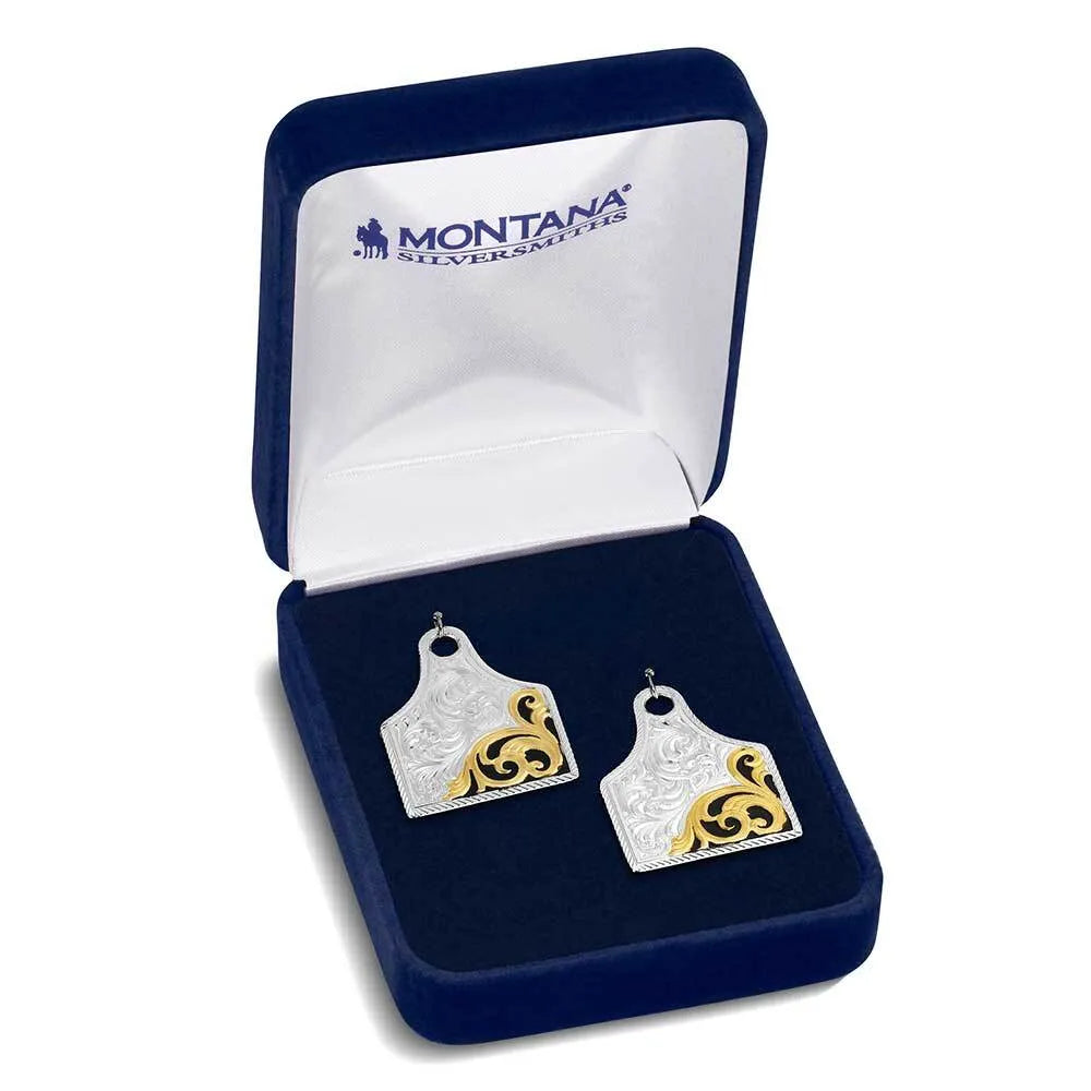 Pair of silver and gold earrings in a Montana Silversmiths box on a white background