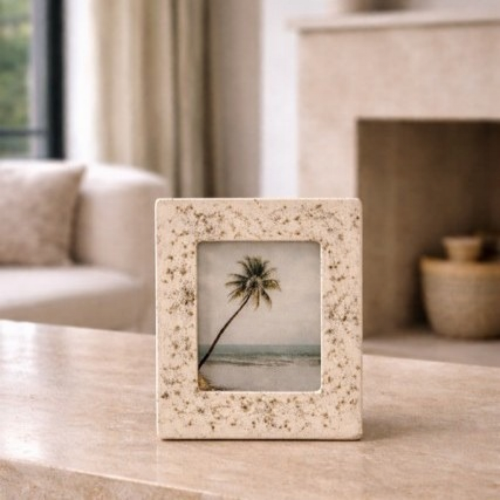 Decorative photo frame with a palm tree picture on a table in a living room.