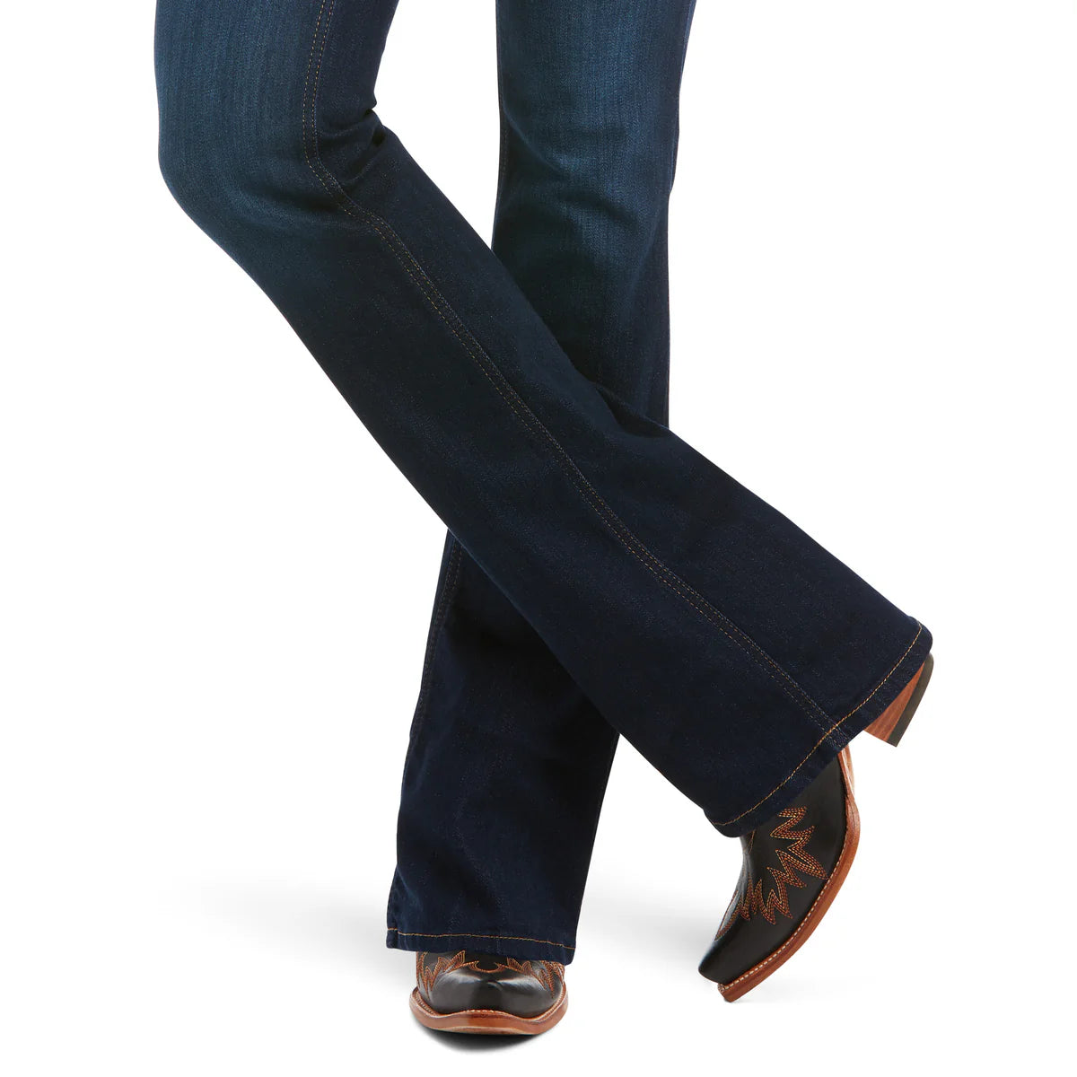 Dark blue jeans worn with brown leather boots on a white background