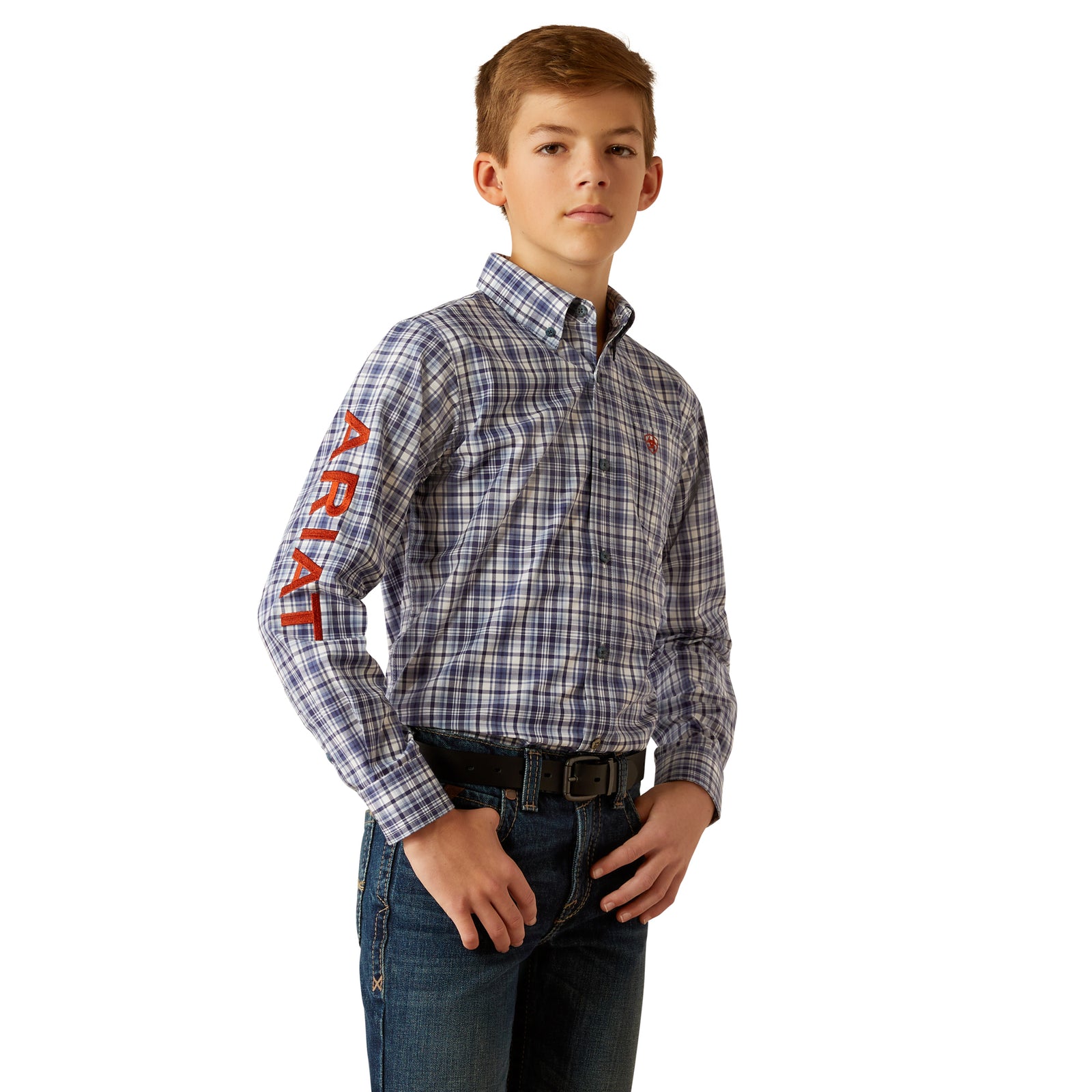 Ariat Boy's Pro Series Team Orion L/S Western Shirt. A boy wearing a long-sleeved plaid Western shirt in blue and white colors with the brand name 'Ariat' visible on the sleeve.