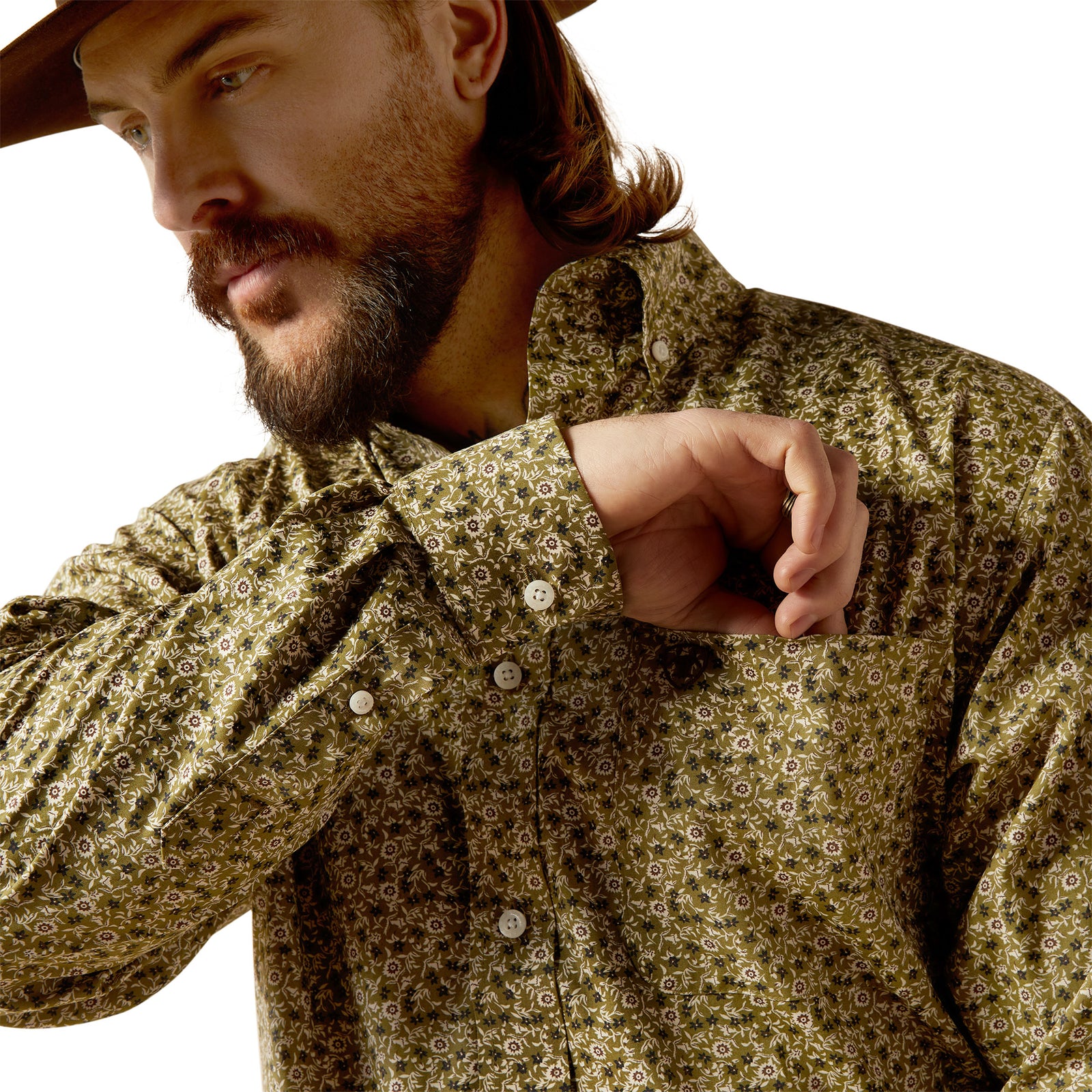 Ariat Men's Wrinkle Free Filmore L/S Western Shirt. Man wearing a patterned shirt with rolled-up sleeves, looking to the side.