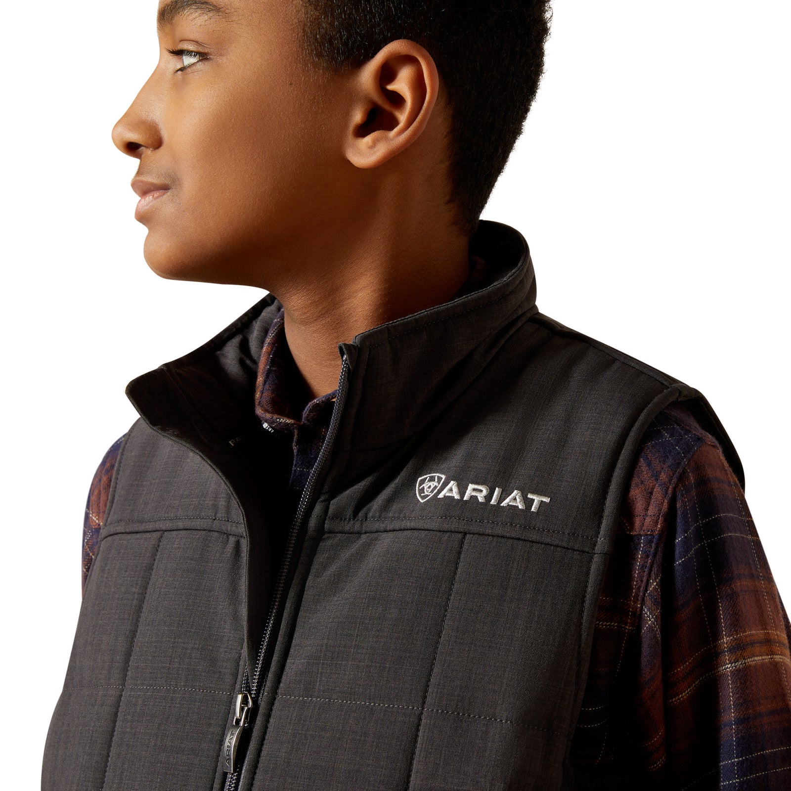 Child wearing a black Ariat vest on a white background