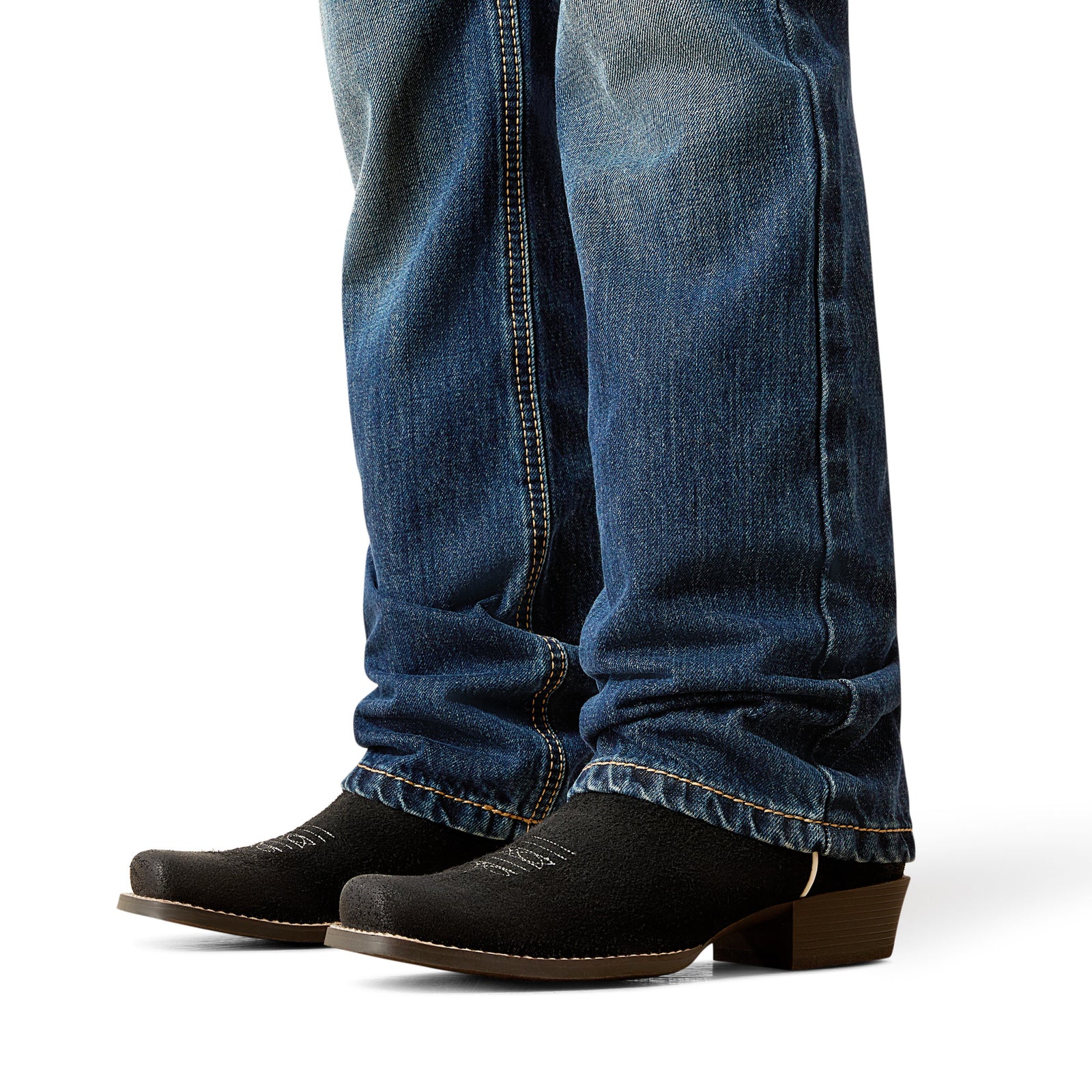 Close-up of blue jeans and black boots on a white background