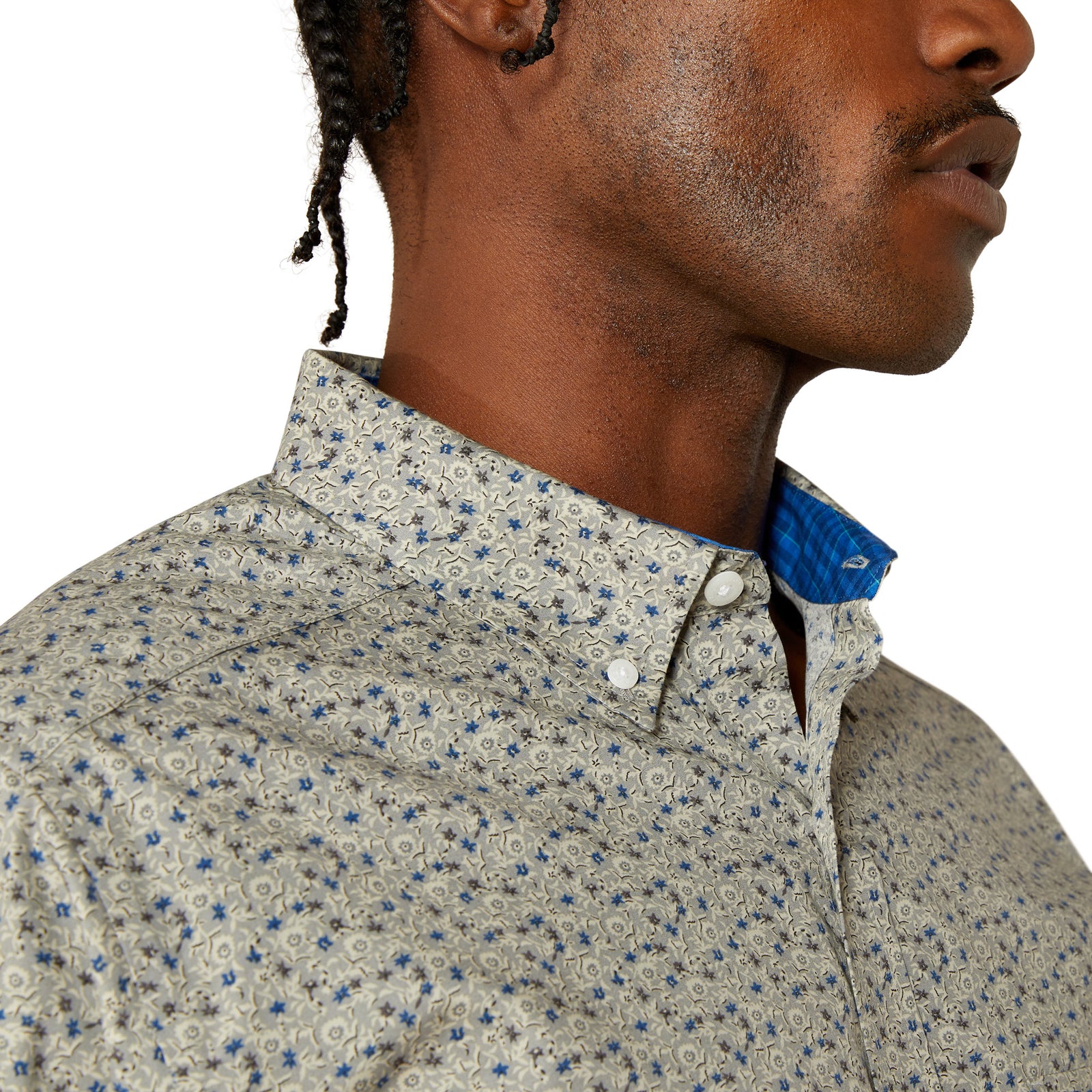 Close-up of a person wearing a patterned shirt with a blue collar.
