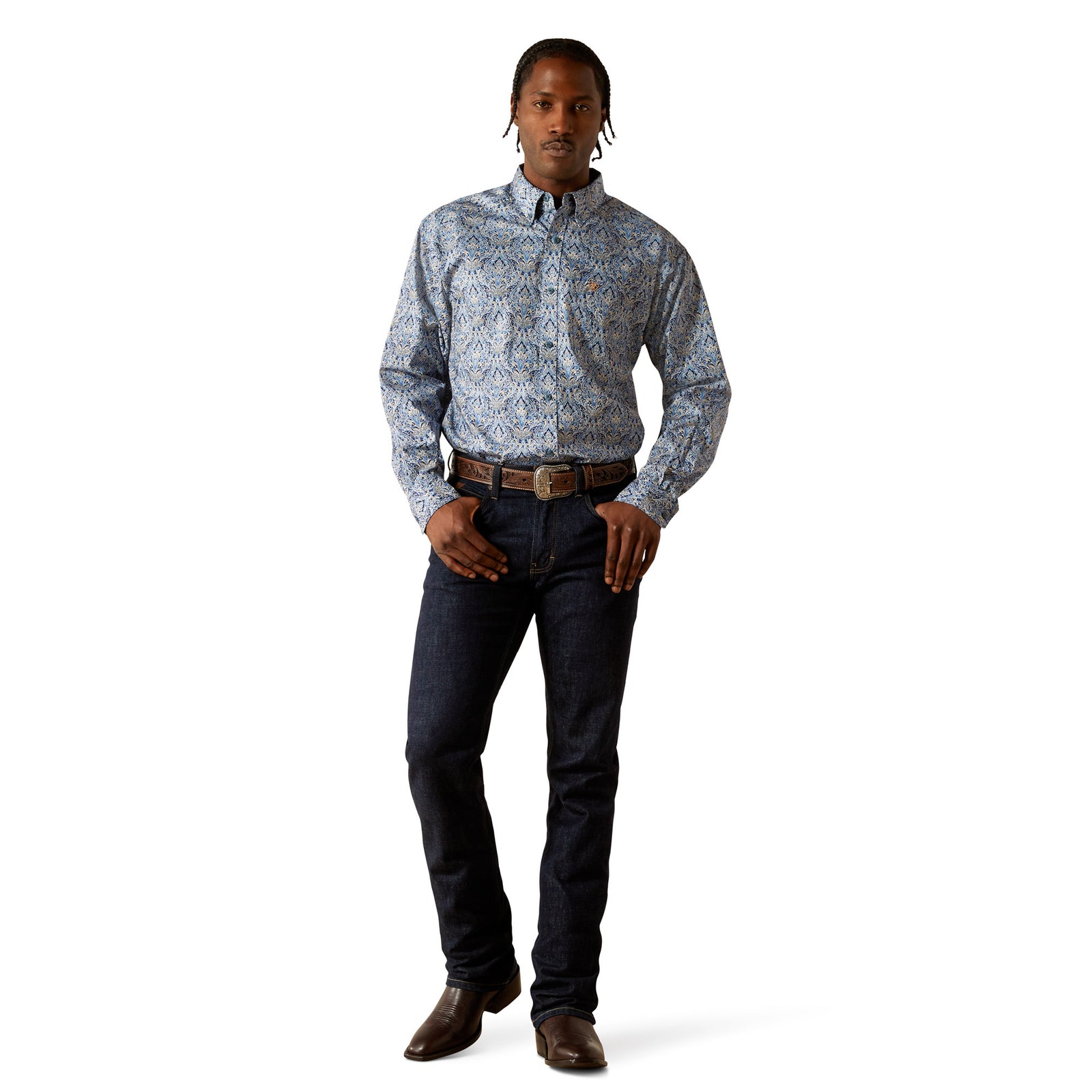 Man wearing a patterned shirt and dark jeans on a white background