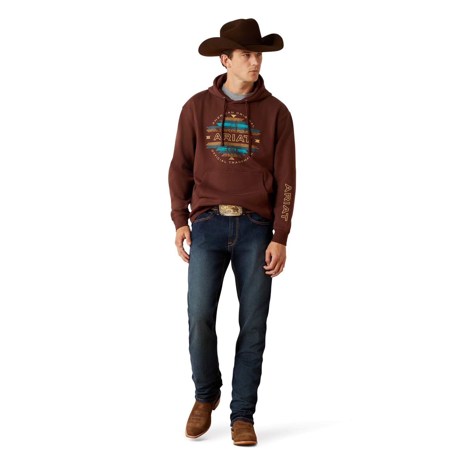 Man wearing a brown hoodie with a pattern, blue jeans, and a cowboy hat on a white background