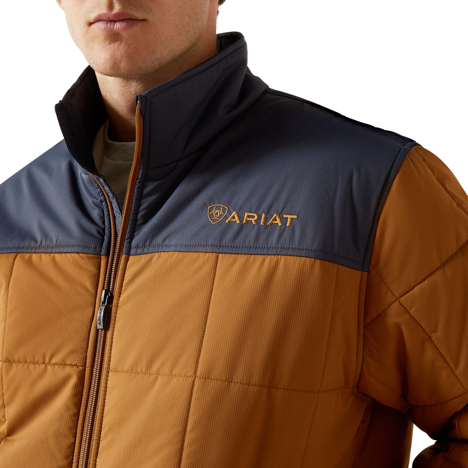 Brown and navy puffer vest with Ariat logo on a white background